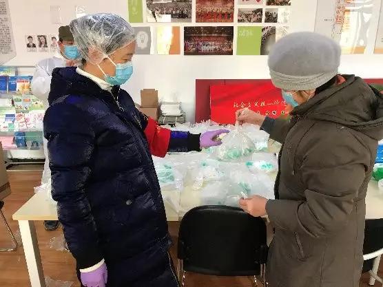 為樓棟分發口罩,并為包裝袋消毒